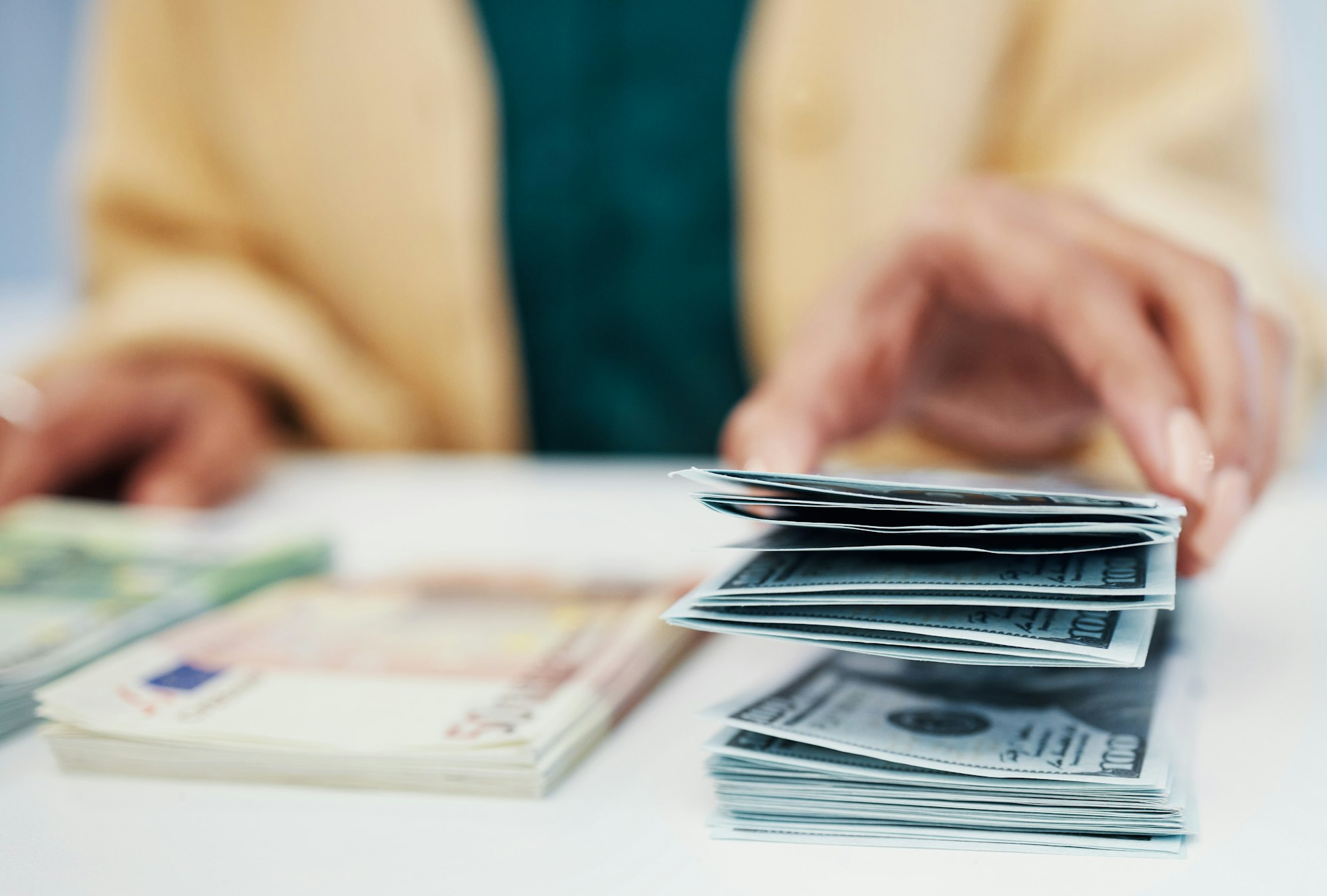 Hands, finance and a business person counting cash closeup in the office of a bank for accounting.