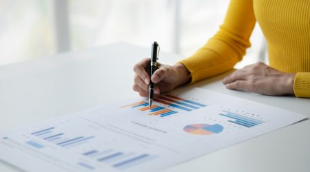 A female financier is reviewing company financial documents, monthly financial statement summary.