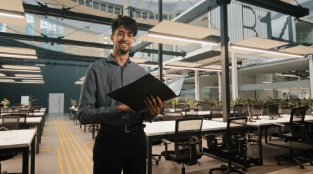 Young indian latin manager male business man employee checking document folder inspecting financial